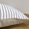 Corner of a Two Tone cushion with Stripes on Top and beige canvas on the bottom