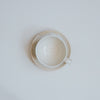 Cream stoneware coffee cup and saucer from above