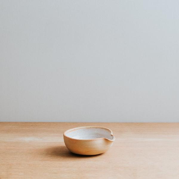 Small natural oil bowl with white glaze and textured exterior