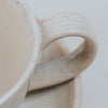 Close up of cream coffee cup and saucer handle