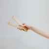 Hands Holding Wooden Tongs