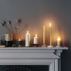 Handmade nontoxic candles on a grey fireplace
