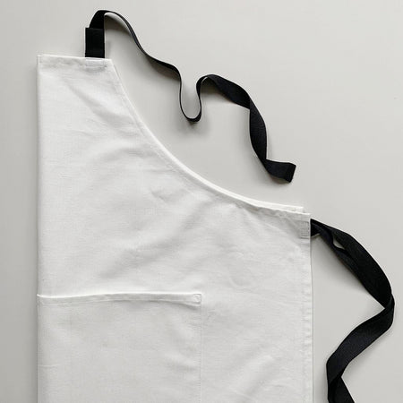 Off white cotton apron with black straps