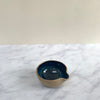 A small blue pouring bowl on a marble background